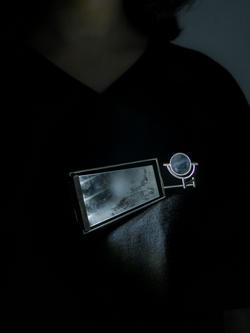 A metallic and mirror artwork is set against a dark background.
