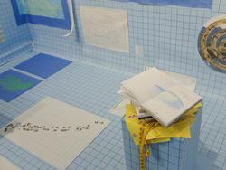 Graphic Design student work by Sejal Gupta of various books and charts set against a blue and black grid background.