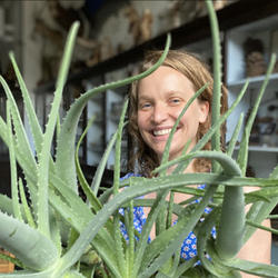 Georgia Rhodes peeps out from behind a succulent