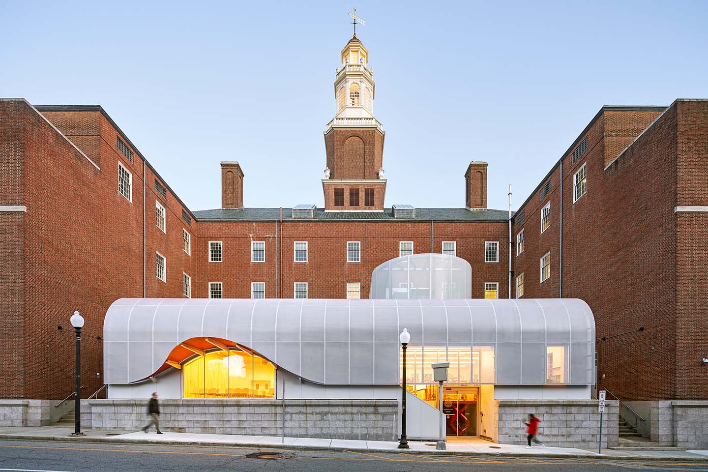 View of RISD’s main building, 20 Washington Place, at dusk. Building is a mix of traditional brickwork and contemporary architectural elements.